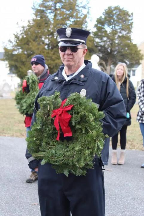 Chief Engineer, Chuck Doyle, holds a wreath prior to placing it on a veteran's grave. Photo courtesy of Jon Hill.