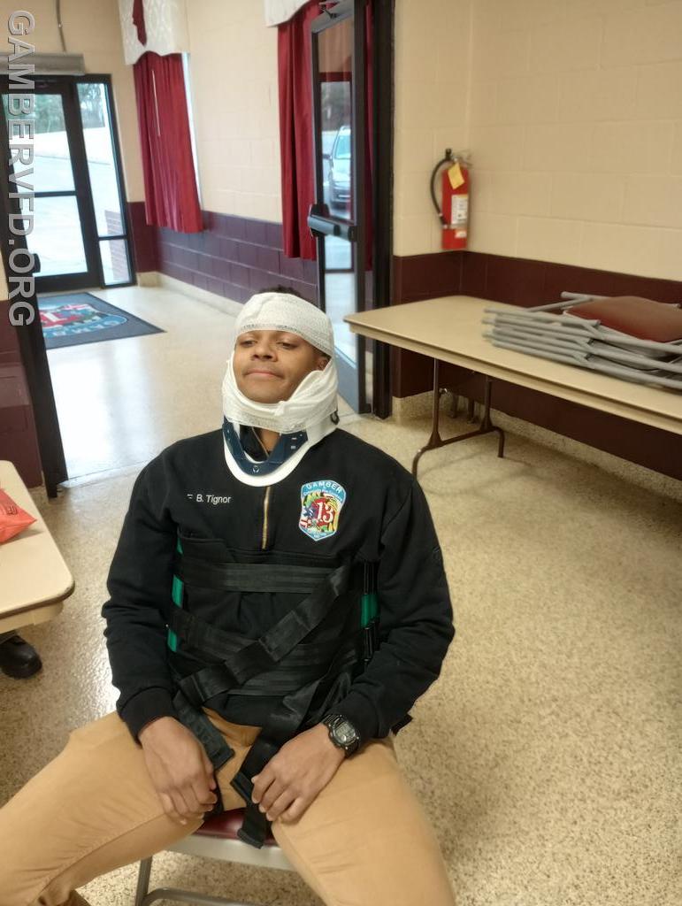 A Gamber senior member, Brandon Tignor demonstrates spinal immobilization as the patient.