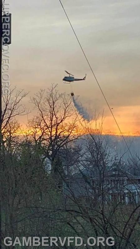 A Maryland Dept. of Natural Resources helicopter drops a load of water on the fire.