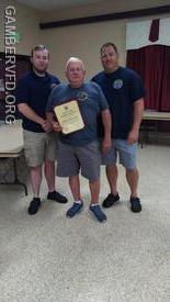 Denis Leppert displays his certificate at the Gamber company meeting on July 21. President Todd Tracey (l) and Chief Chad Hastings presented the award.